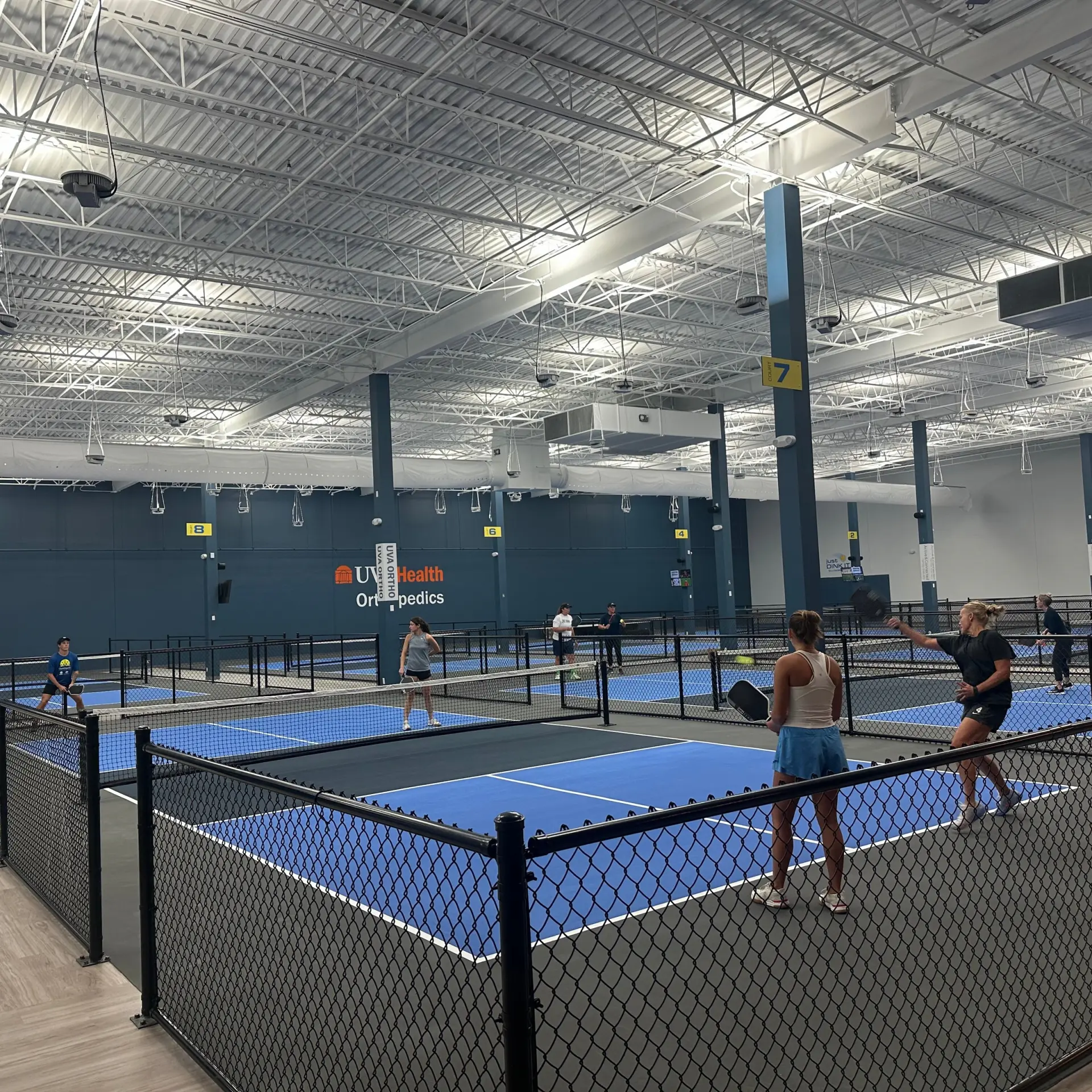 Players on the indoor pickleball courts at cvilleSMASH in Charlottesville, VA